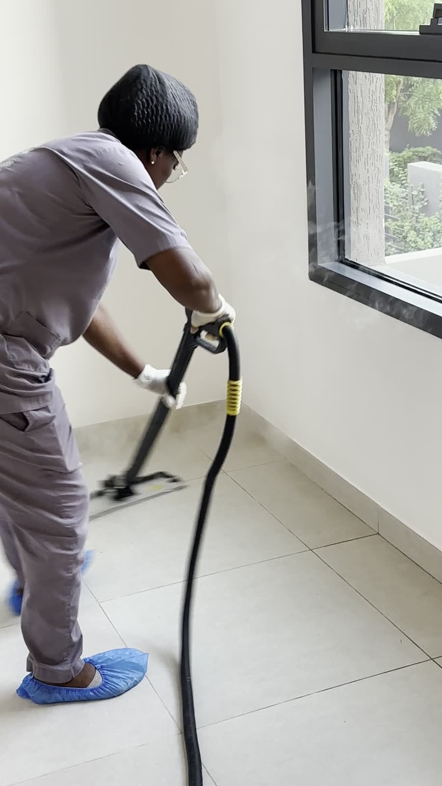 Fliesenboden wird mit dem Dampfwischer gereinigt