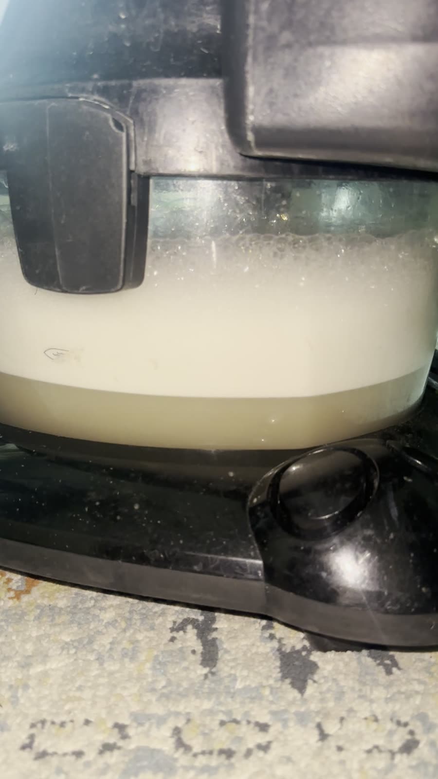 Wassertank des Extraktionsgeraets nach der Arbeit, schmutziger Schaum