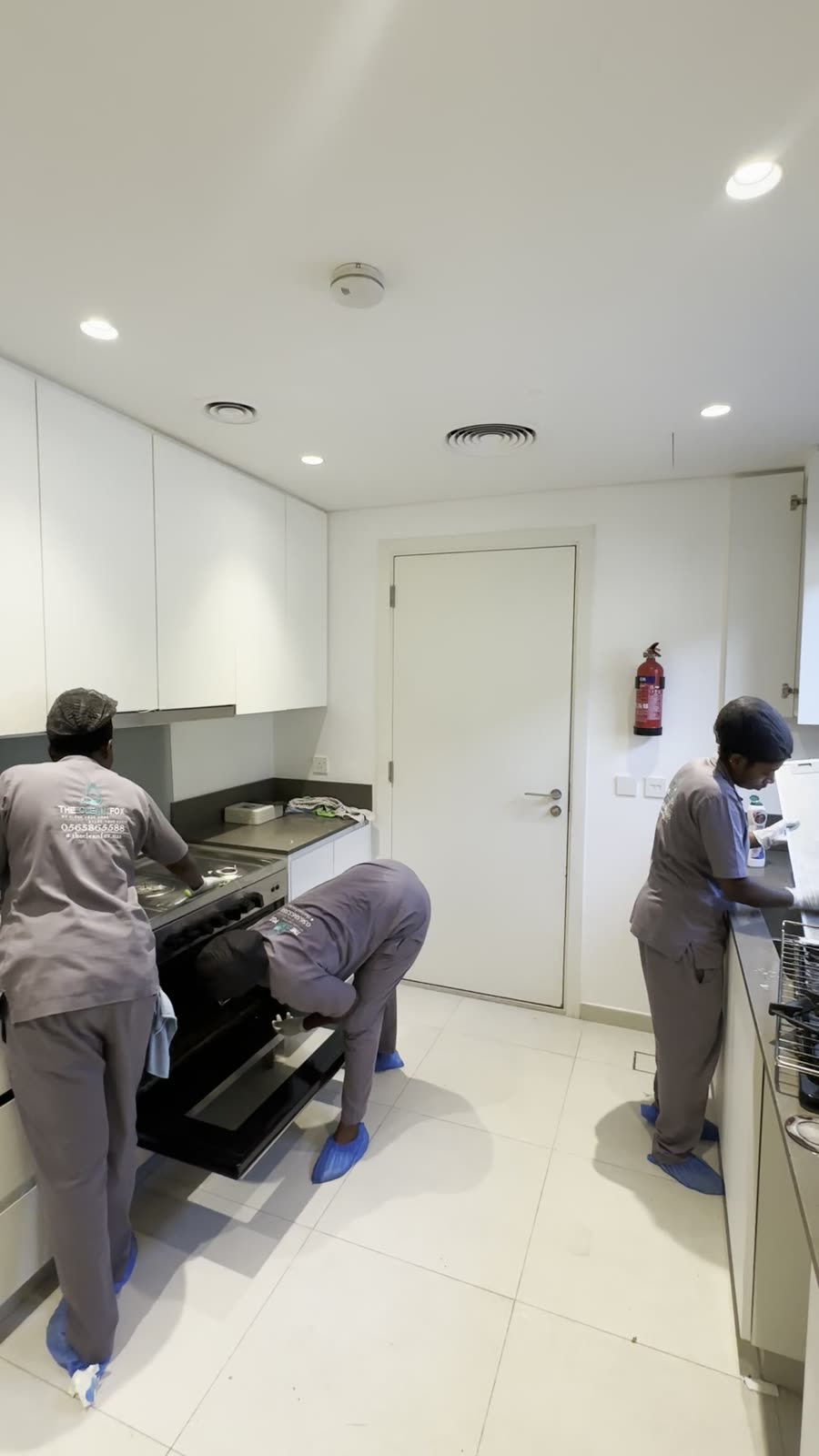 Zwei Mitarbeiter reinigen Kueche und Backofen
