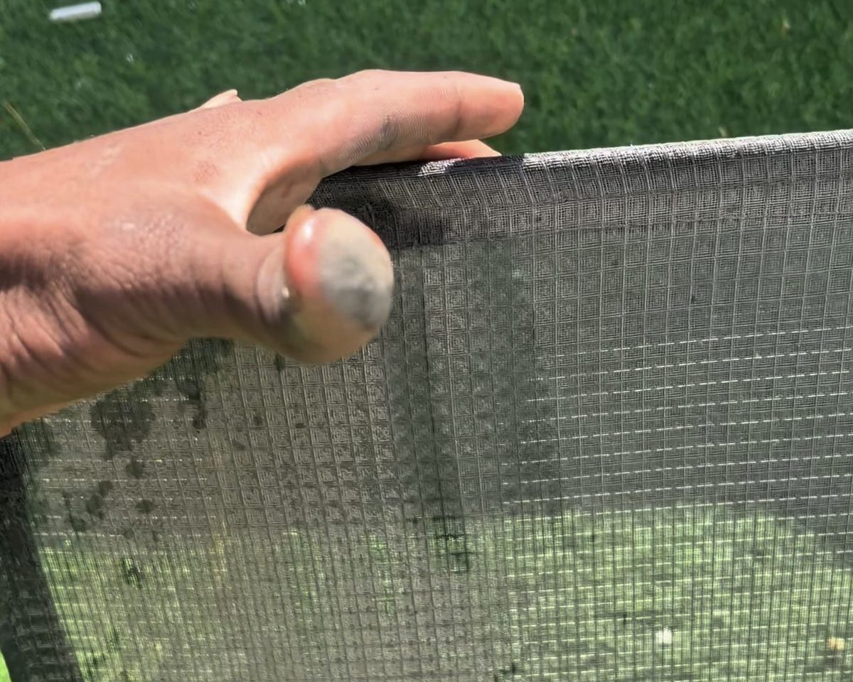 Echtes Foto: Techniker haelt einen Klimafilter, Fingerkuppen grau vom Staub