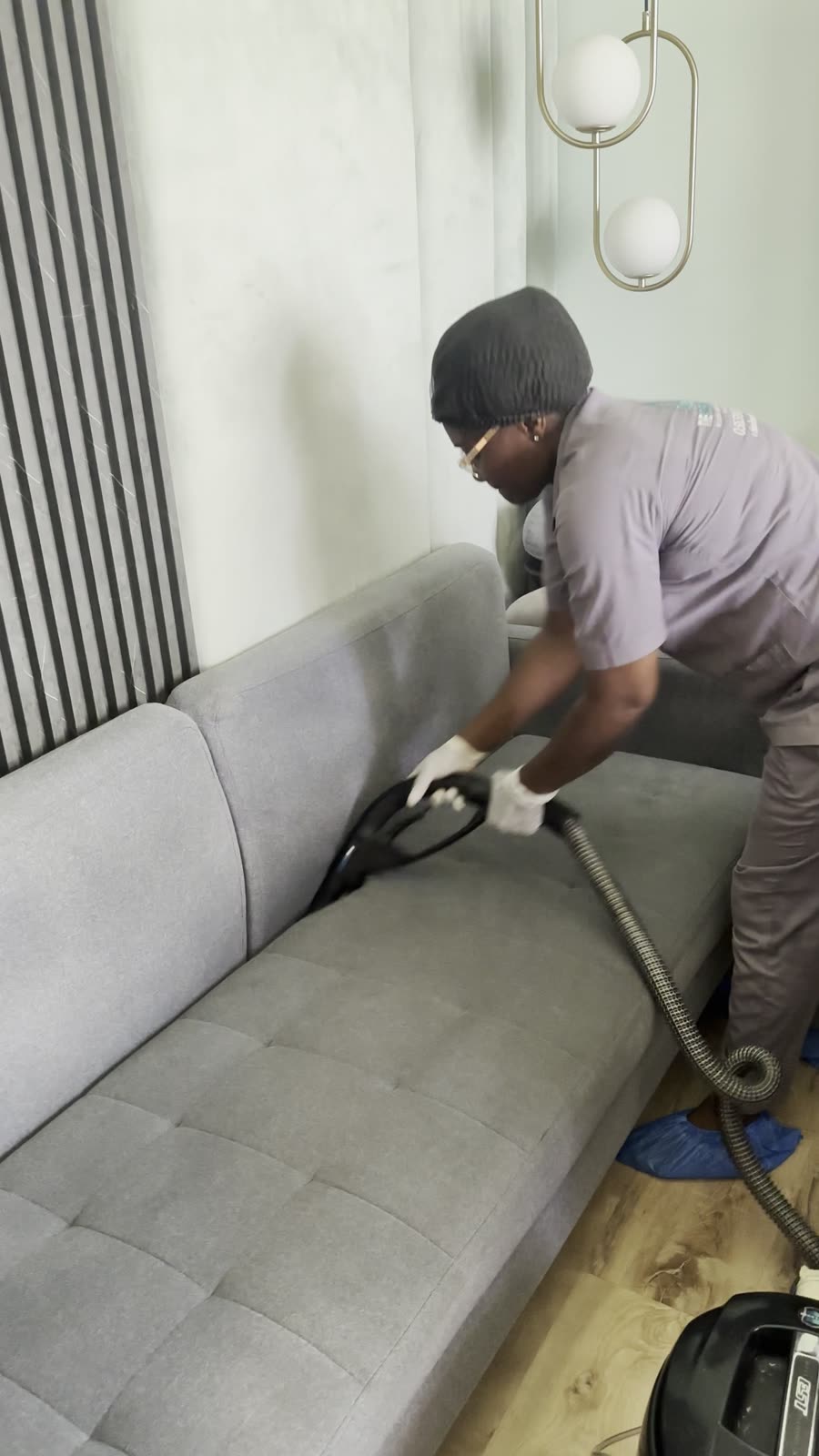 Sofa wird mit Handschuhen abgesaugt